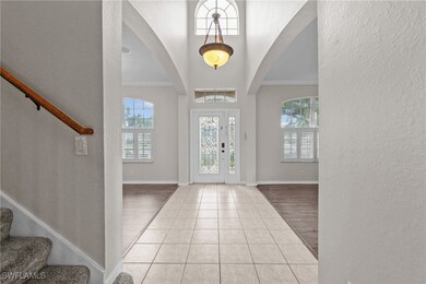 Entrance foyer featuring crown molding, arched wal