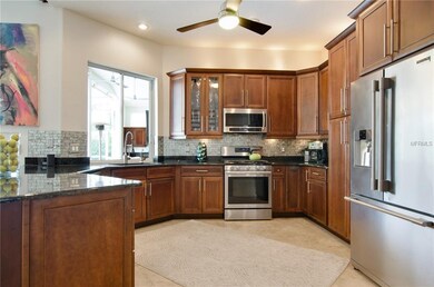 The kitchen has custom wood cabinets, granite coun