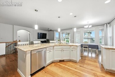 Kitchen featuring stainless steel dishwasher, arched walkways, light wood-type flooring, healthy amount of natural light, and recessed lighting