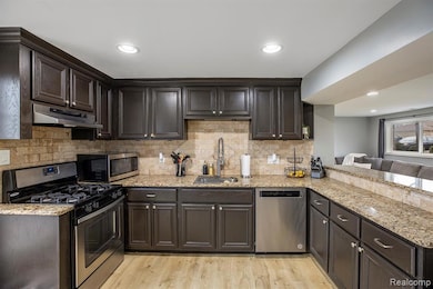 Kitchen with stainless steel appliances, light wood flooring