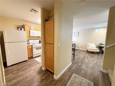 Kitchen featuring white appliances, dark wood fini