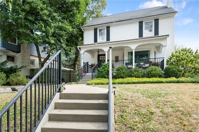 View of front of home featuring a porch, stairs, a front lawn, and a chimney