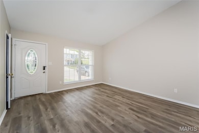 Entrance foyer with vaulted ceiling and dark wood finished floors