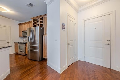 Kitchen with stainless steel appliances, dark wood-type flooring, open shelves, baseboards, and ornamental molding