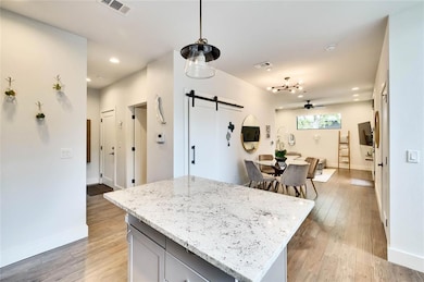 Kitchen featuring a barn door, a ceiling fan, lig