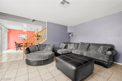 Living area with stairway, tile patterned floors,