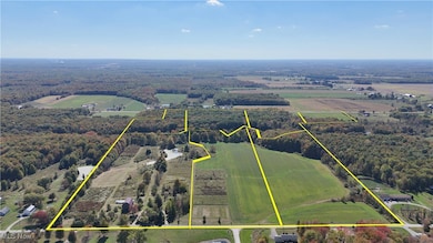 Overview of rural landscape featuring property parcel outlined and a forest