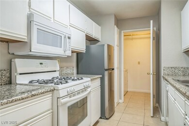 Kitchen featuring white appliances, white cabinets