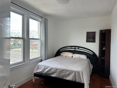Bedroom with dark wood-style flooring and crown molding