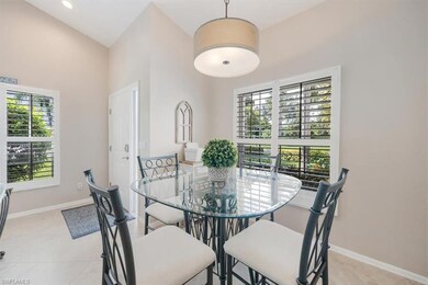 Dining room with light tile patterned flooring and a towering ceiling