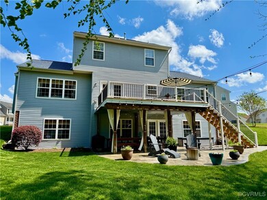 Back of house with stairway, a patio, a yard, and