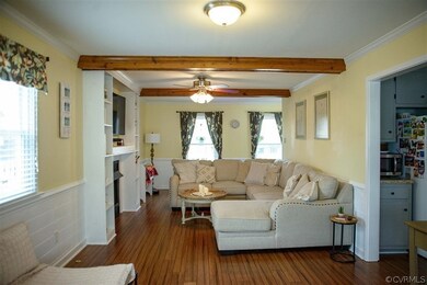 Living room featuring beam ceiling, dark hardwood