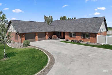 View of front of home with brick siding, an attached garage, driveway, and roof with shingles