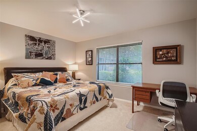 Carpeted bedroom featuring baseboards and a desk