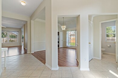 Welcoming foyer leads to an elegant dining room with a convenient half bath nearby.