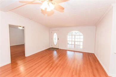 Foyer entrance featuring crown molding, light wood