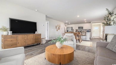 Living room with light wood-type flooring and recessed lighting