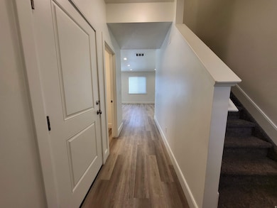 Hallway with light wood finished floors, stairs, and recessed lighting