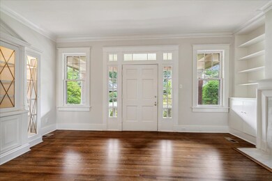 Entrance foyer featuring ornamental molding, dark 