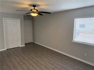 Unfurnished bedroom with ceiling fan and dark hard