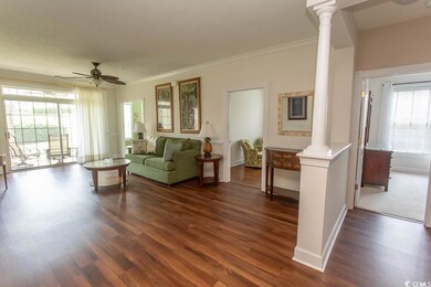 Living area featuring ornate columns, crown moldin