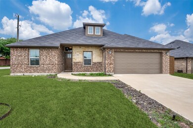 View of front of home with a garage and a front lawn