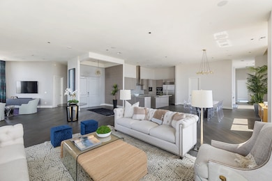 The kitchen, dining, and living spaces flow cohesi