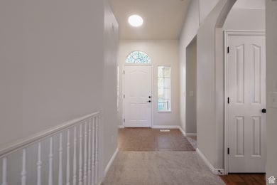 Tiled entryway featuring arched walkways and carpet
