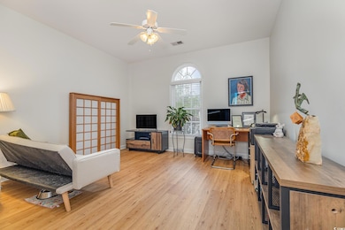 Office space with ceiling fan and light hardwood /
