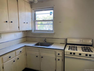 Kitchen with white gas range and light countertops