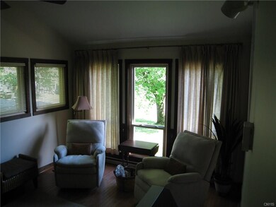 Living room has hardwood flooring and wood burning