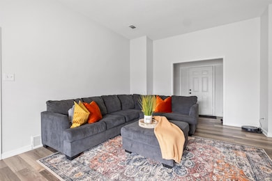 Living area with baseboards, visible vents, and wo