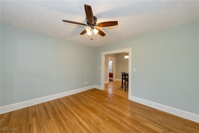 Empty room with ceiling fan and light wood-type flooring