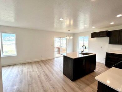Kitchen with a sink, light countertops, light wood-style floors, a chandelier, and recessed lighting