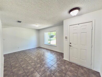 Foyer featuring a textured ceiling, dark tile pat
