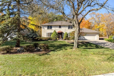 Colonial house with a front yard, a garage, and brick siding