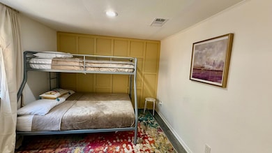 Bedroom featuring crown molding and wood finished floors