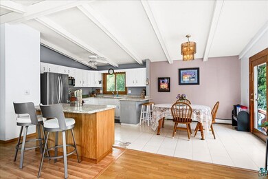 Kitchen featuring vaulted ceiling with beams, appl