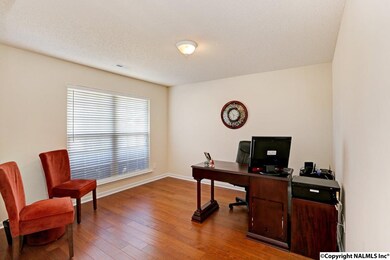 The office has been painted with a neutral color and also features hardwood floors.