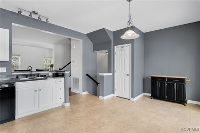 Kitchen with black dishwasher, white cabinetry, ha