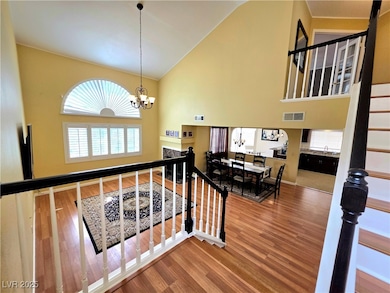 Stairway featuring high vaulted ceiling, wood fini