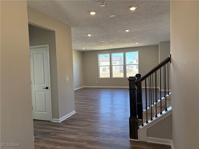 Stairway featuring a textured ceiling and wood finished floors