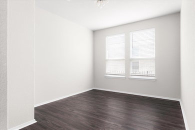 Unfurnished room with dark wood-style flooring and baseboards