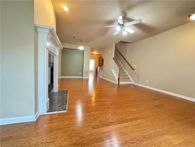Unfurnished living room with ceiling fan, stairs, 