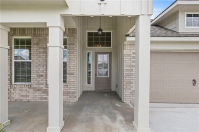 View of exterior entry featuring covered porch, a