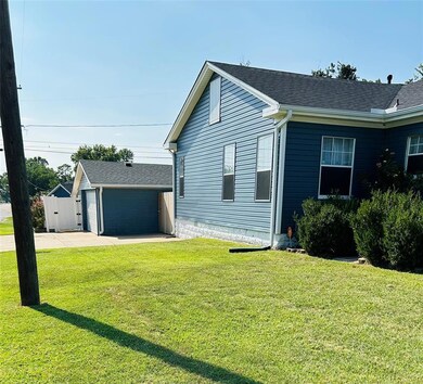 View of home's exterior featuring a lawn, an outbu