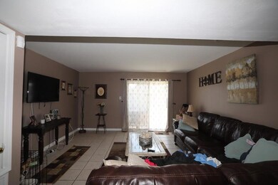 Large den with ceramic tile opens to backyard.