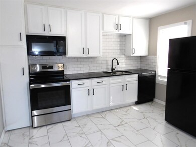 Kitchen featuring backsplash, black appliances, wh