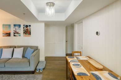 Living room with wood finished floors, wood walls, and a tray ceiling