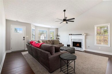Living room with vaulted ceiling, baseboards, dark